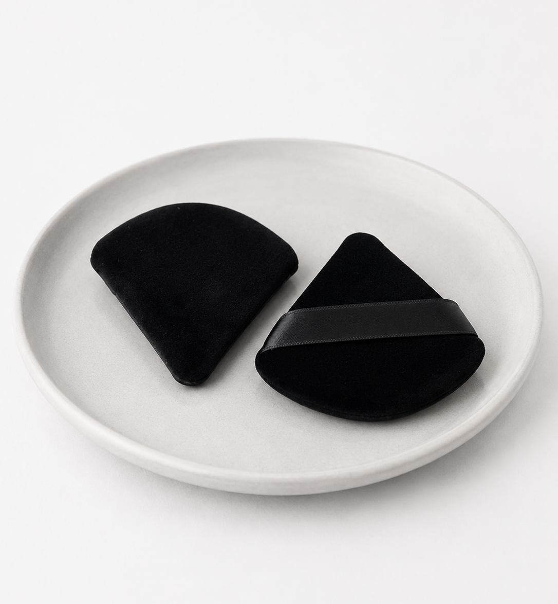 Two black silicone coasters on a white plate with a white background