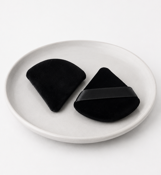 Two black silicone coasters on a white plate with a white background